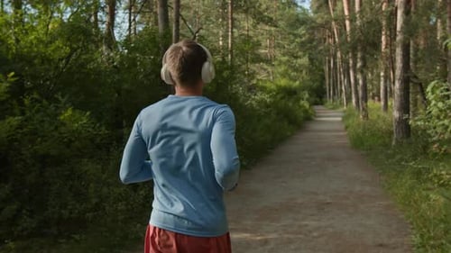 Man Jogging in Forest on Sunny Day
