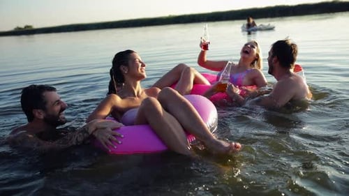 Gruppe junger Freunde, die Spaß haben und einen Sommertag am See genießen.