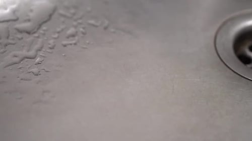 Water Droplets Falling Into a Stainless Steel Sink