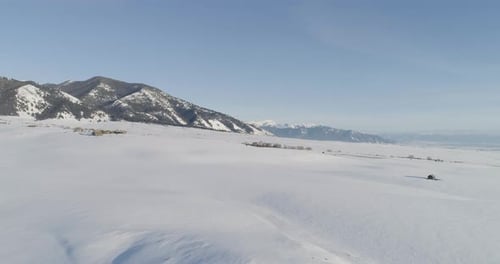 Aerial over snowy valley landscape during winter