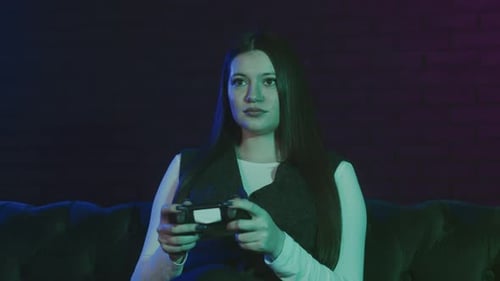 Woman Plays Video Game on Couch at Night