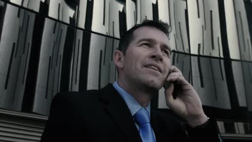 Suits Business Man Talking on His Mobile Phone in Modern Glass City