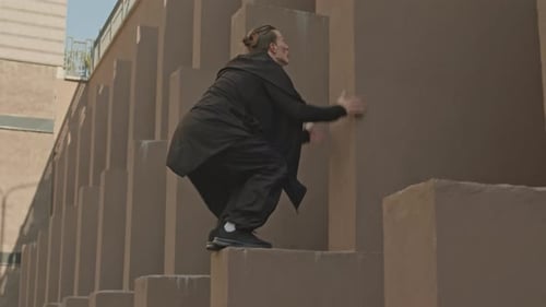 Agile Young Adult Climbs Wall Doing Parkour