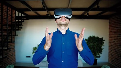Man gesturing while using a Virtual Reality headset in an office