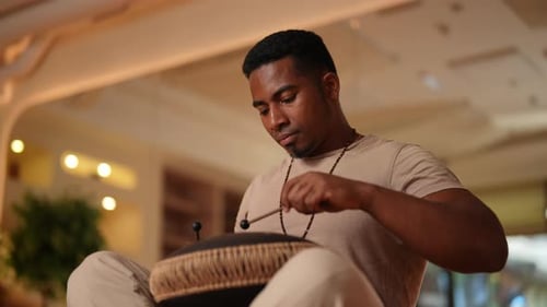 Shooting From Below of Relaxed African Man Playing Traditional Ethnic Music on Glucophone Using