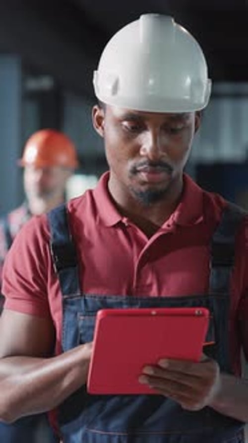 A Focused Worker is Utilizing a Tablet in a Dynamic Construction Environment to Enhance Productivity