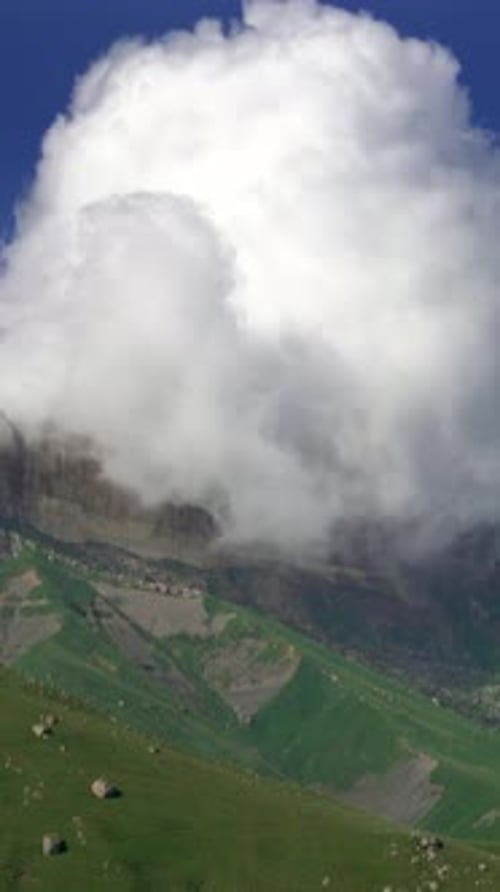 Mountain partially hidden by clouds in vertical landscape