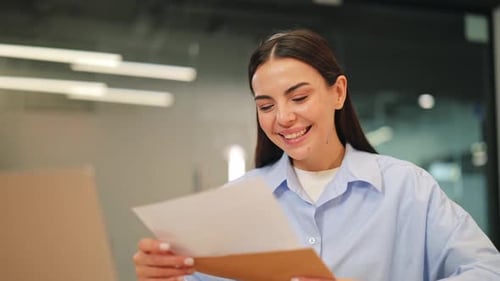 Joyful Woman Reads Positive News in Office Letter