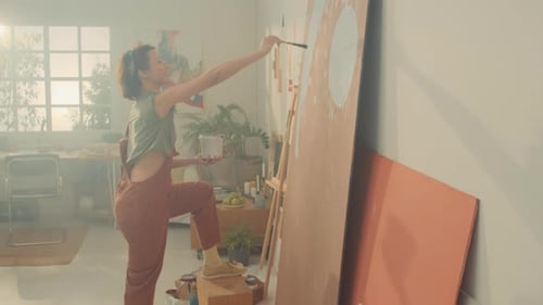 Female Artist Creating Large Abstract Painting in Studio