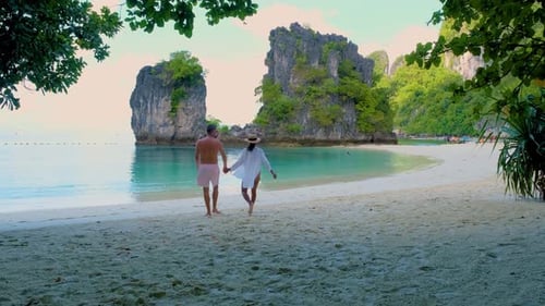 Couple Walking Hand in Hand on Serene Beach in Koh Hong Krabi Thailand During Golden Hour