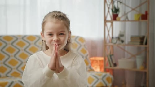 Niña en edad preescolar pregunta insistentemente con un gesto de oración