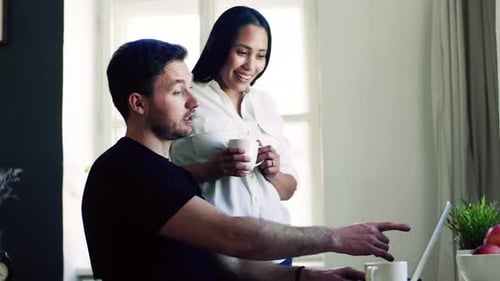 Couple works together using laptop at home