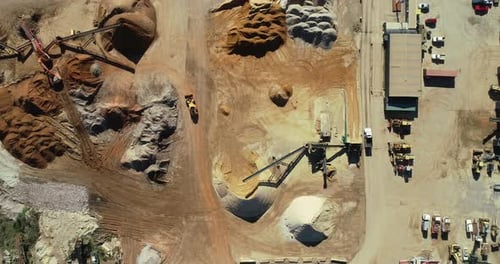 Heavy quarry machinery moving parallel in tandem as they move through live quarry facility.