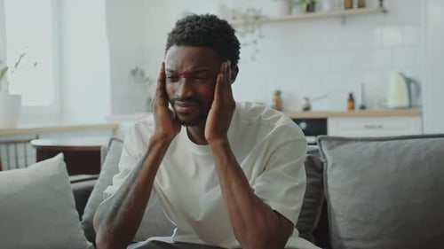 Man Experiencing Headache and Stress in Home