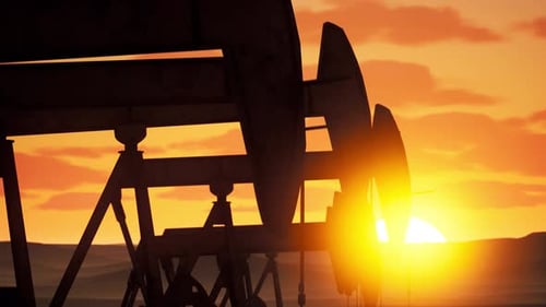 Sunrise Over Oil Pumps In An Expansive Oil Field