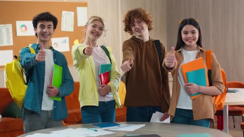 Smiling Teens Giving Thumbs Up in Classroom