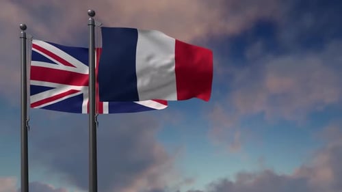 United Kingdom and French Flags Waving Against Cloudy Sky