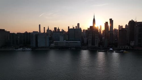 An aerial view of Manhattan from over the East River in NY at sunset, during Manhattan Henge. The