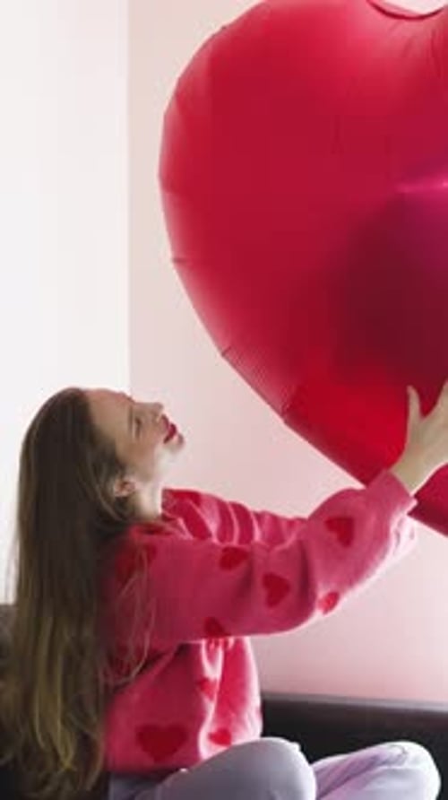Young Woman Holding a Heart Shaped Balloon Indoors