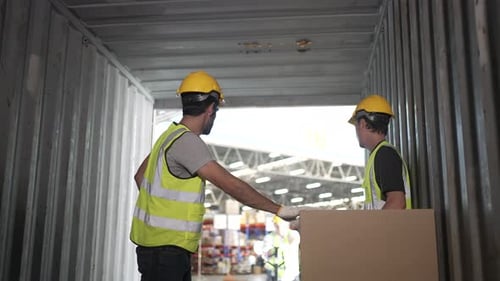 Blue collar workers are working at warehouse.