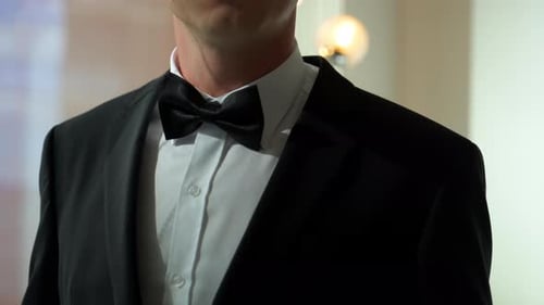 Man Adjusting Black Bow Tie in Formal Attire