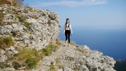 Adventure Trip Young Woman Hiker with Dreadlocks Walking on the Edge of a Mountain