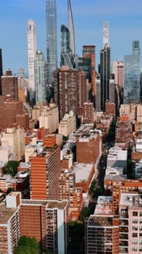 Bright sun lighting the facades of multistoried buildings and skyscrapers of New York.