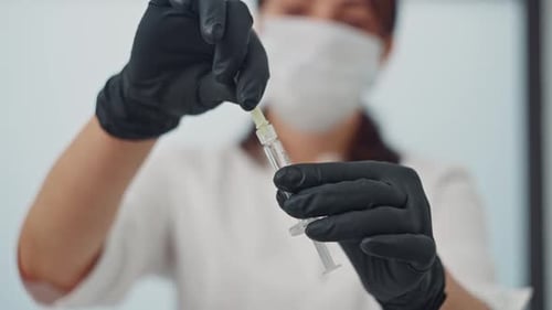 Healthcare Professional Attaching Needle to Syringe in Hospital