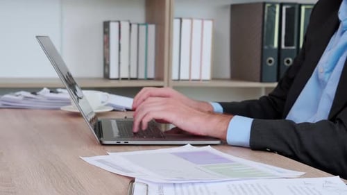 Professional Typing on Laptop in Bright Office