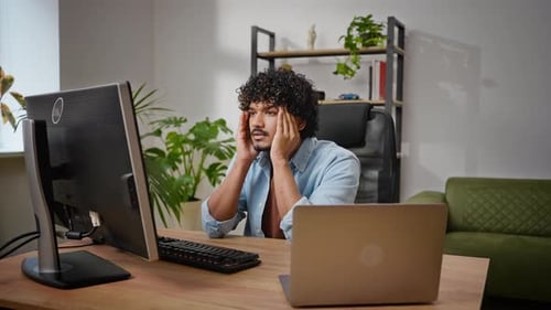 Man Contemplates Computer Screen While Working from Home