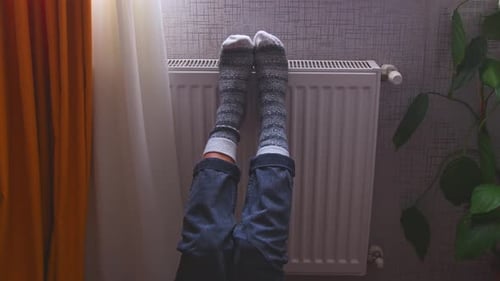 Feets In Woolen Socks On Radiator To Warm