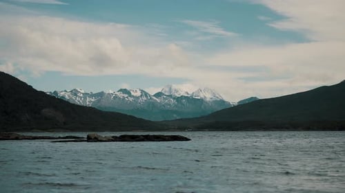 Majestic Snow Capped Mountain Peaks Overlooking A Calm Deep Lake
