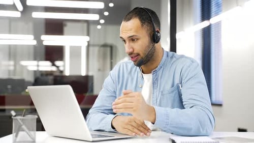 Young Adult in Meeting with Headset and Laptop