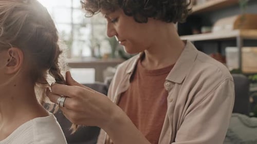 Mother Unbraiding Daughters Hair