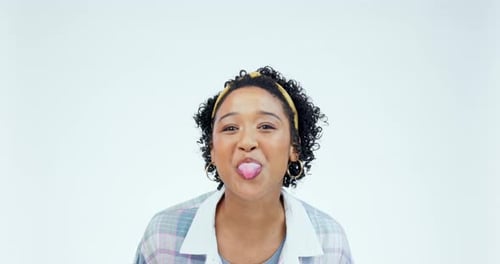Divertido, rostro y mujer con la lengua fuera y una sonrisa en fondo blanco de estudio