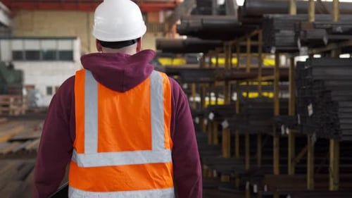 The inventory control inspector walks through the workshop and takes notes.