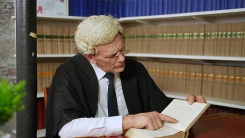 A judge or barrister reading in a law library with wig and gown