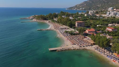 Side view of Summer beach, ocean and front hill resorts, azure sea water Drone Aerial establishing s