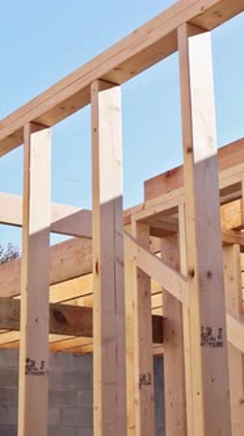 Construction of Wooden Framework Under Clear Blue Sky at Building Site