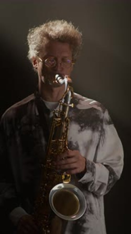 Talented Male Musician Playing Saxophone and Looking at Camera
