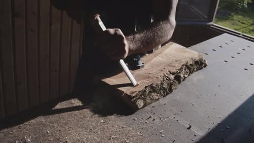 Woodworker Chiseling Wood Piece in Workshop