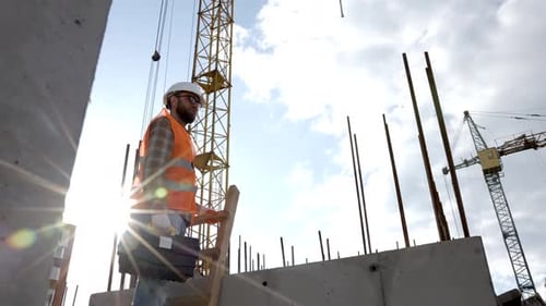 Construction Worker at Building Site with Crane
