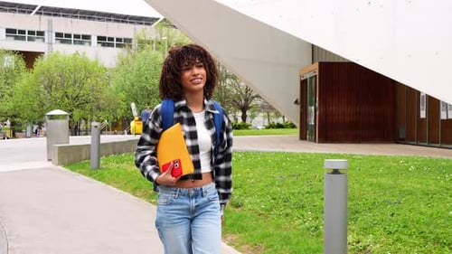 Young African American Student Walking on University Campus