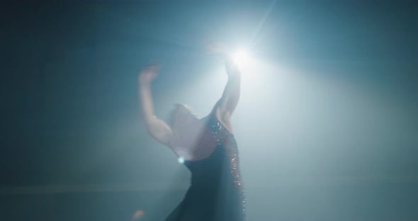 Cinematic shot of young female artistic figure skater is performing a ...