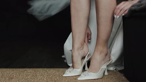 Woman Puts on Jeweled White High Heel Shoes