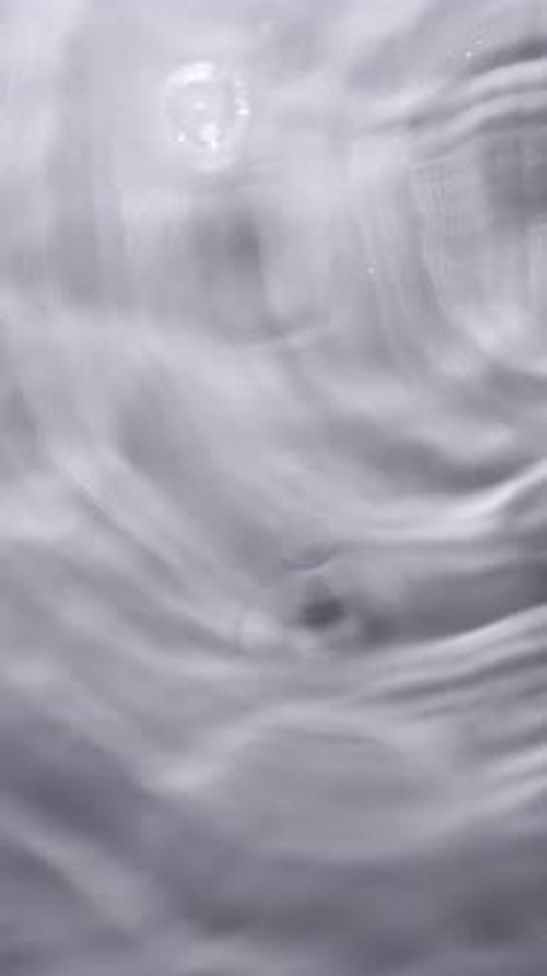 Water Droplets Ripple Smoothly on a Gray Background