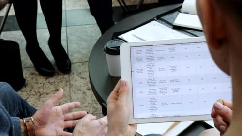 Business Meeting Discussing Data on a Tablet