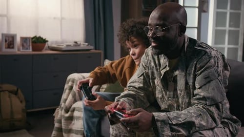 Child and Adult Laughing Playing Video Games Together