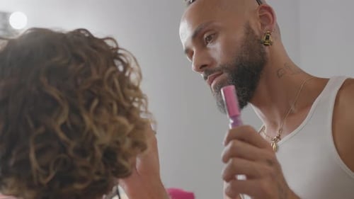Gay Man with Tattoo Applying Makeup on Woman in Studio Close Up