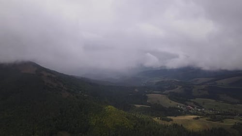 Aerial Panoramic Time Lapse Drone Flies Through the Low Clouds in Cloudy Weather Over Mountains